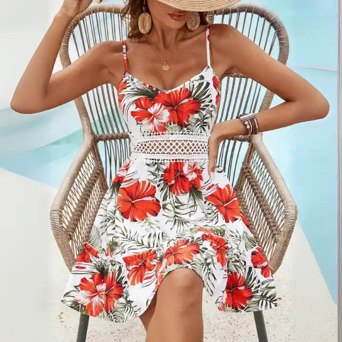 red hibiscus spaghetti strap dress by pool with tropical chairs and sunhat giving chic summer vacation vibe