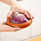 red onion storage container with retractable membrane being held to demonstrate size and proper usage for halved produce