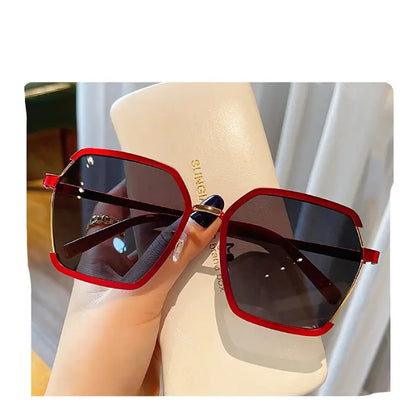 Luxury red metallic square frame sunglasses with dark gradient lenses displayed on cream leather case