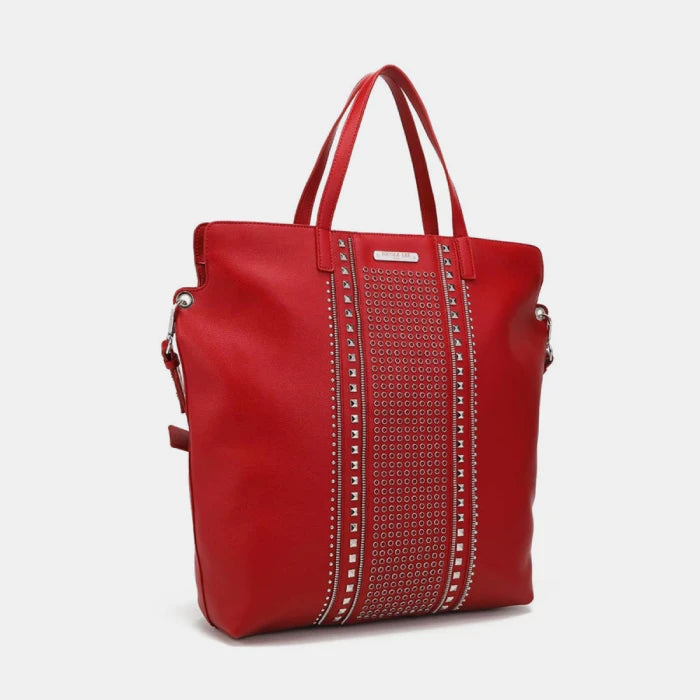 Stylish red leather tote with decorative studding and pyramid hardware shown from side angle for luxury handbag shoppers