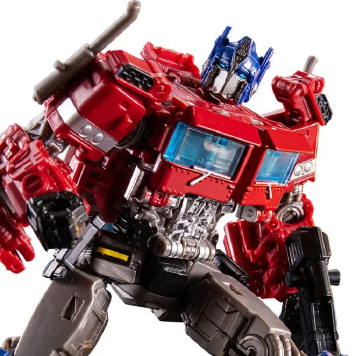 Close-up view of a red and blue transforming robot with intricate mechanical details and a blaster in hand.