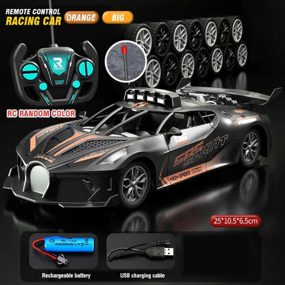 Orange large remote control racing car with rugged design, controller, spare tires, battery, and USB charging cable.