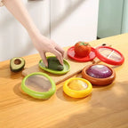 reusable produce storage containers displaying colorful holders for avocado, tomato, onion and lemon on wooden surface