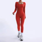 Ribbed knit jumpsuit in vibrant red captured mid-walk, showing a sculpting one-piece outfit designed for confident and striking style