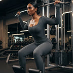 Ribbed knit jumpsuit in dark grey during focused strength training at the gym, emphasizing supportive one-piece outfit for powerful movement