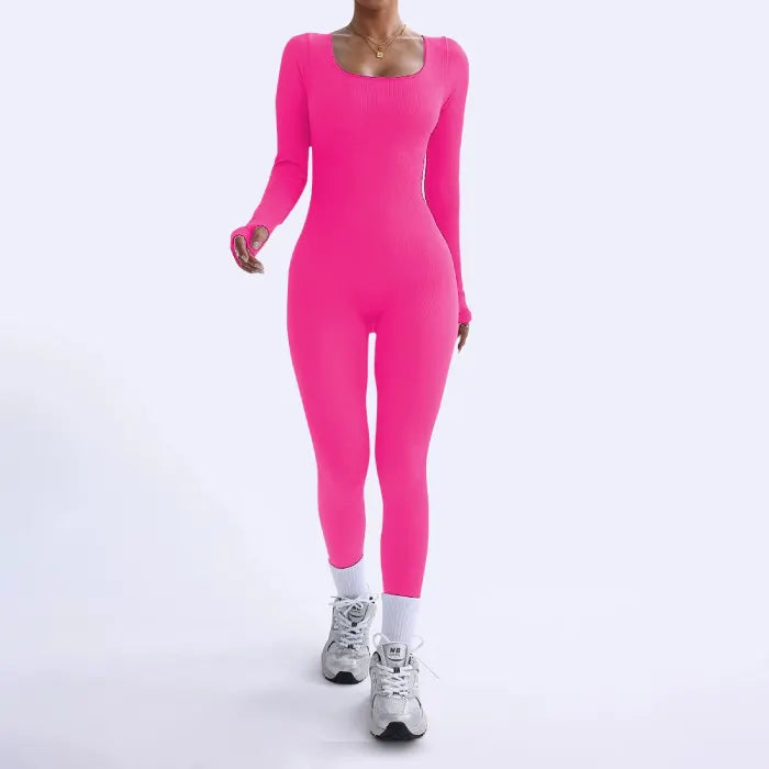 Ribbed knit jumpsuit in bold hot pink shown mid-stride, featuring a fun stretch one-piece outfit perfect for energetic, expressive styling