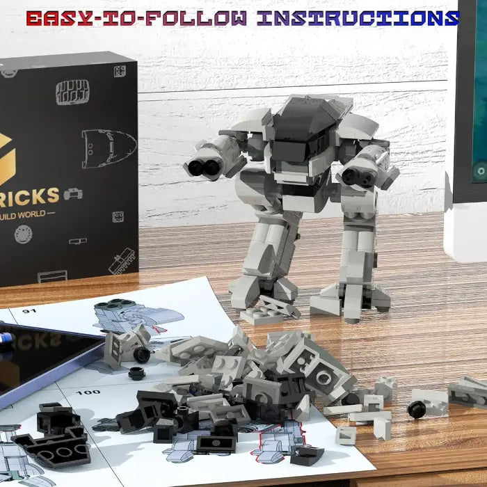 Gray robot building kit with assembly instructions and scattered parts on a wooden desk.