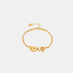 Delicate gold-plated snake chain bracelet featuring LOVE letters with crystal-studded heart charm and adjustable clasp