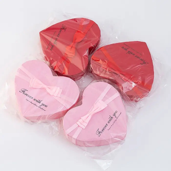 Heart-shaped pink and red gift boxes wrapped in plastic with "Forever with you" design text.