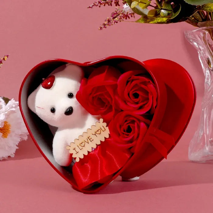 Styled photo of red heart gift box with teddy bear and roses against pink background