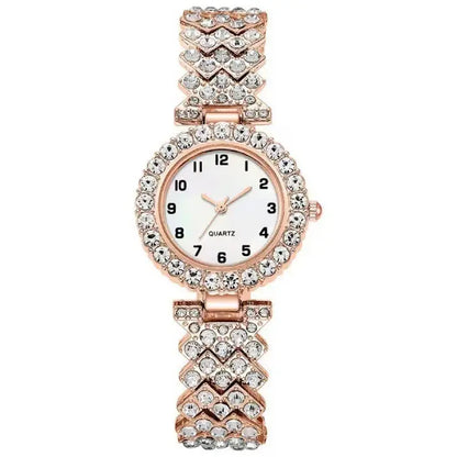 Rose gold quartz wristwatch with a white face and a chevron-patterned diamond like-studded band.