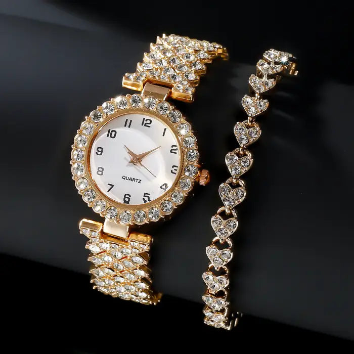 Rose gold diamond like-studded quartz wristwatch paired with a matching heart-design bracelet on a black background.