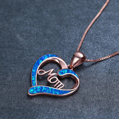 Rose gold mom heart necklace with shimmering blue opal inlay on textured background for special occasions.