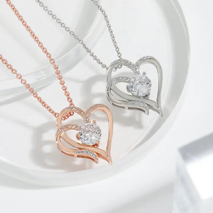 Pair of rose gold and silver plated heart-shaped necklaces with sparkling stones, perfect for elegant gifting.