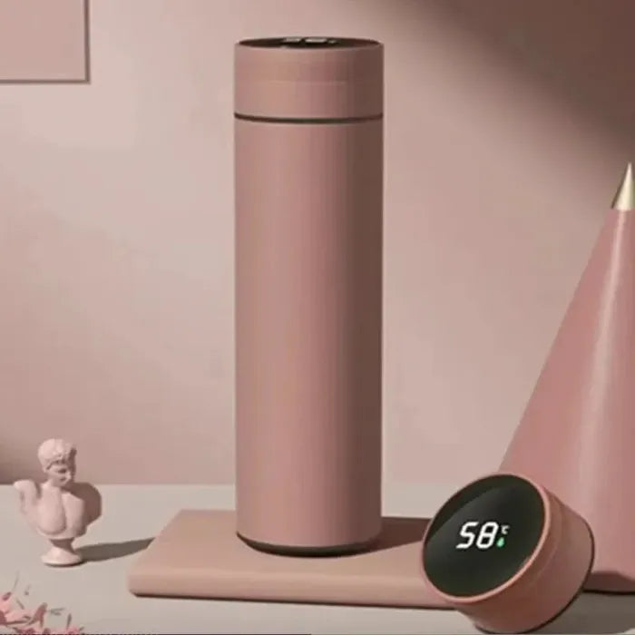 Rose gold smart bottle with temperature display, decorative bust, and geometric shapes in pink-toned setting