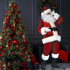 Santa costume adult standing near red and gold Christmas tree with presents and festive decor.