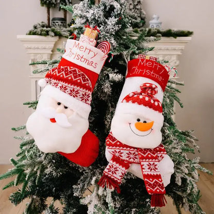 Two Christmas stockings with Santa and snowman designs hanging on decorated Christmas tree branch with ornaments