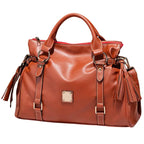 Satchel handbag in brown leather with tassels and structured front view design