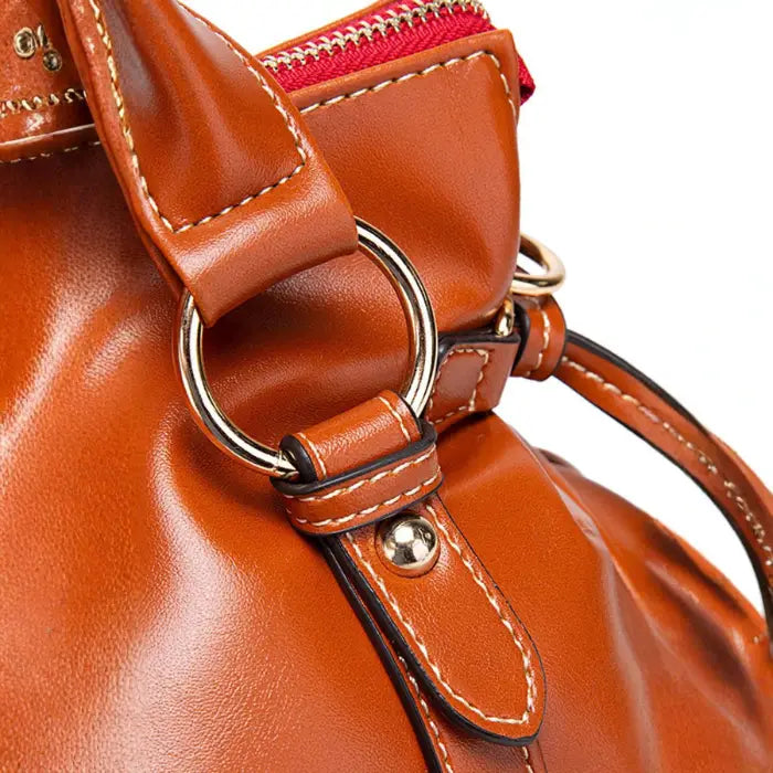 Satchel handbag hardware detail with close-up of ring and stitching on leather handle