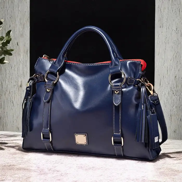 Satchel handbag in navy blue leather with gold hardware and red zipper lining