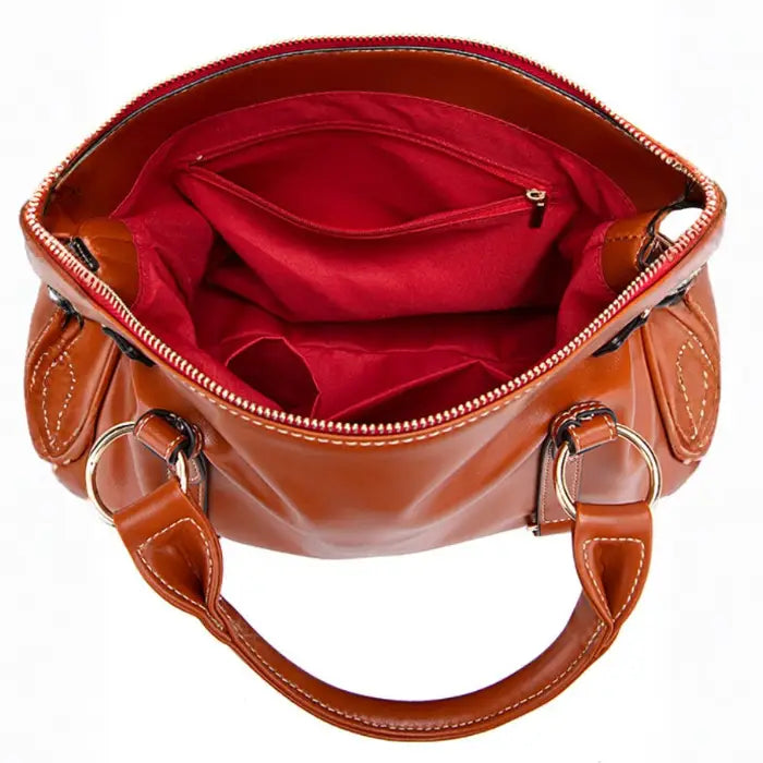Satchel handbag top view with red interior lining and zippered compartments