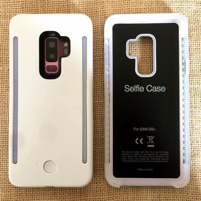White selfie case with LED lights turned on next to a transparent case for Samsung S9 Plus.