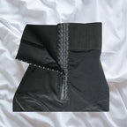 Shapewear laid flat showing triple hook-and-eye front closure with high waist design.