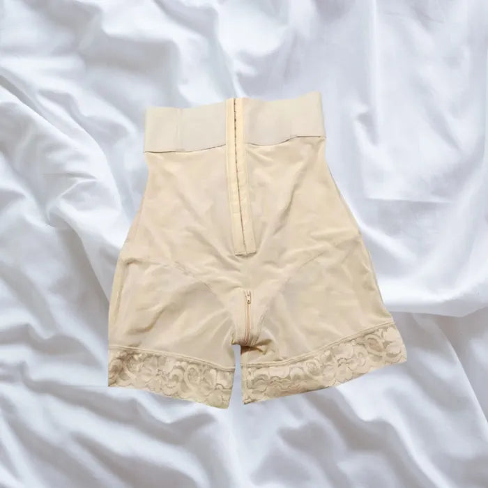 Nude-colored shapewear with hook closure and floral lace trim for seamless waist shaping.