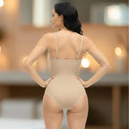Back view of beige shapewear underwear bodysuit modeled with soft candle-lit indoor setting.
