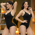 Two models in black shapewear underwear bodysuits side posing in wellness-inspired room with candles.