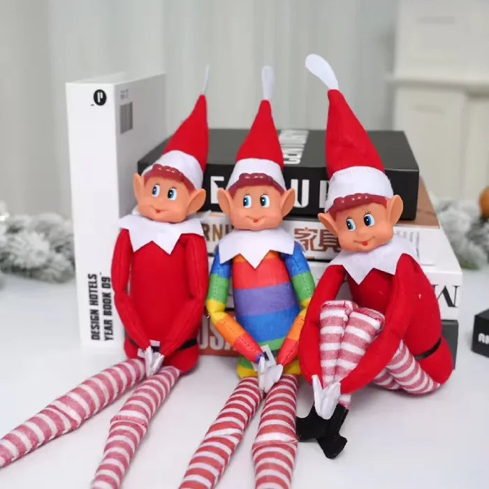 Three Christmas elves arranged on books with decorative background