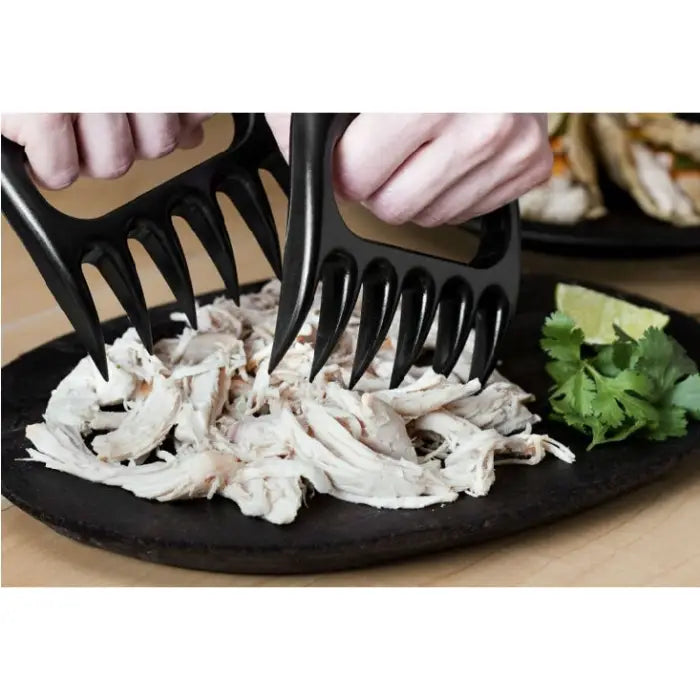 Shredding chicken using black meat claws, perfect for efficient meat handling and food preparation.