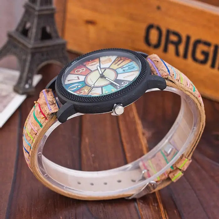 Side view of a colorful analog wristwatch with cork strap, showcasing intricate vintage-inspired design.