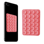 Pink silicone phone holder with suction cups displayed on a smartphone, providing firm attachment for hands-free mobile viewing