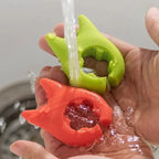 Silicone Utensil Holder being washed under running water in green and red