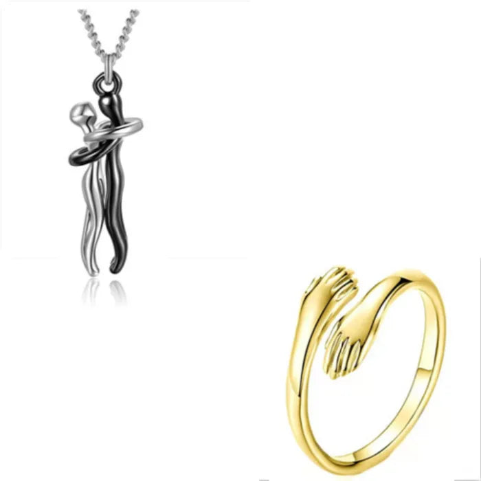 Silver and black couple embrace pendant necklace accompanied by a golden hand wrap ring for jewelry lovers.