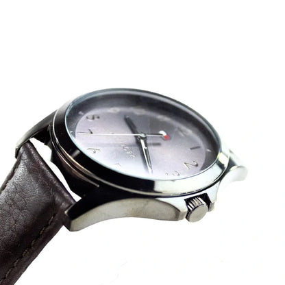 Tommy Hilfiger watch crown details and polished silver case construction with leather band attachment