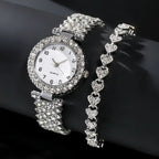 Silver diamond like-studded quartz wristwatch with a matching heart-shaped bracelet displayed on a black background.