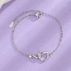 Dainty silver heart infinity bracelet with a sparkling crystal and adjustable chain clasp design.
