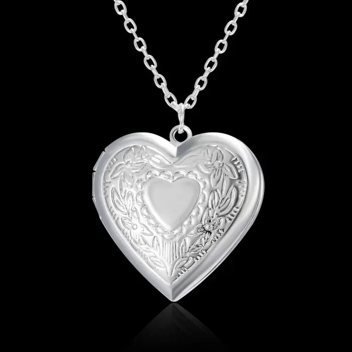 Silver heart-shaped locket with intricate floral design, perfect for meaningful personalized jewelry.