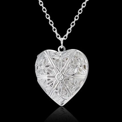 Silver heart-shaped locket with detailed geometric patterns for elegant and unique jewelry gifts.