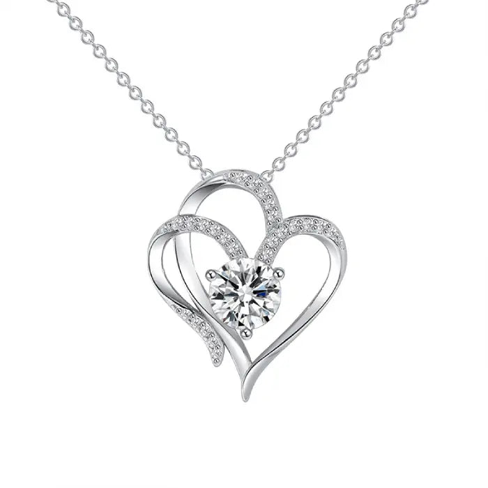 Silver heart-shaped pendant with a sparkling center stone, displayed clearly against a white background.