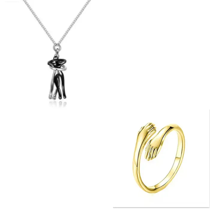 Modern silver couple hug pendant necklace paired with a stylish gold hand embrace ring for unique