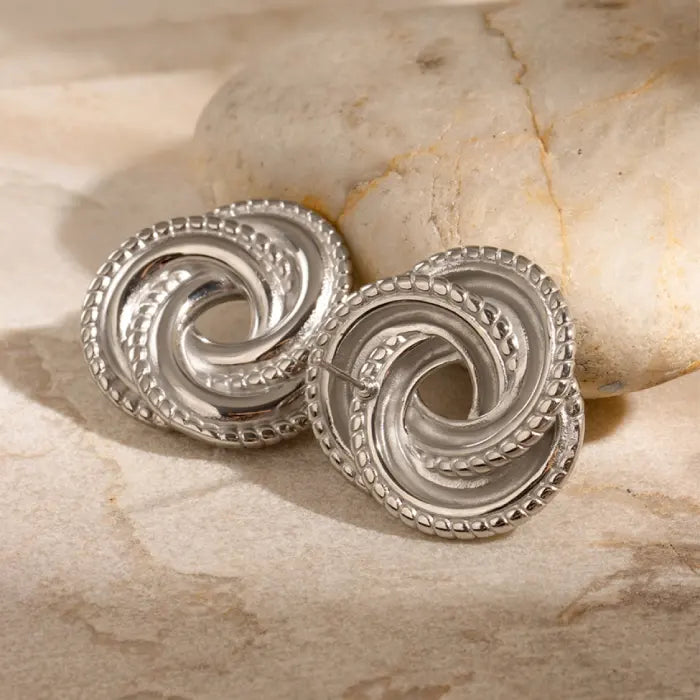 Beautiful silver knot earrings displayed on marble, highlighting intricate details for a classy jewelry option.
