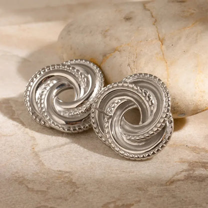 Beautiful silver knot earrings displayed on marble, highlighting intricate details for a classy jewelry option.
