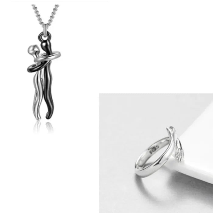 Sleek silver hand embrace ring with a modern design paired with a silver couple pendant necklace.