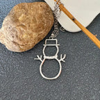 silver snowman earrings necklace pendant near rock showing shiny metal detail