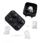 Skull ice cube silicone tray opened with four detailed mold cavities ready to fill.