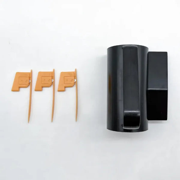 sliding wrapping paper cutter black body with three orange replacement blade inserts on white background.