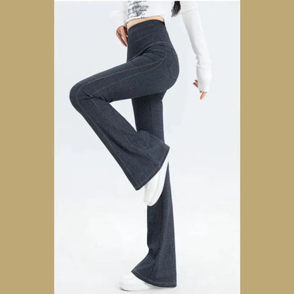 Side view of dark denim flared leg pants with high waist, paired with white top and shoes, showcasing the wide-leg silhouette